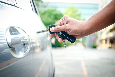The male hand holds the key to unlock the door to open the car.